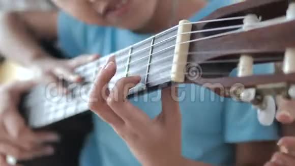 一位母亲近距离地教女儿如何演奏古典吉他家庭活动为自学c视频的预览图
