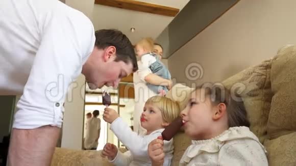 快乐的家庭孩子和父亲分享冰淇淋和巧克力手持视频的预览图