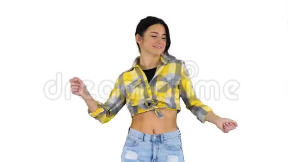 女孩穿着方形衬衫和牛仔裤短裤运动鞋在白色背景上跳舞视频的预览图