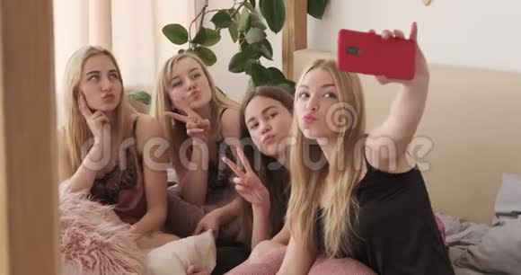 快乐的少女们在睡眠派对上用手机自拍视频的预览图