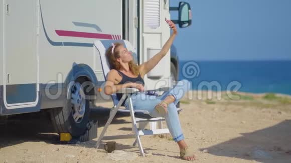 女孩在她的露营者附近自拍旅行妇女由移动汽车之家房车露营车视频的预览图