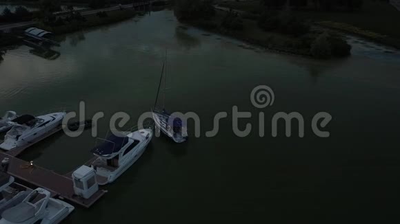 河鸟瞰豪华游艇停泊在海湾日落或黎明阳光美丽地照亮了船山脉视频的预览图