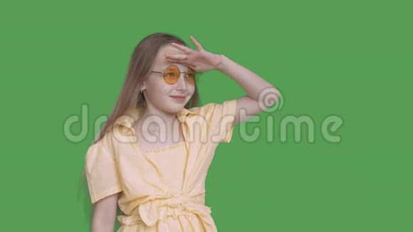 少女远望透明绿色背景戴着黄眼镜和礼服的年轻女孩视频的预览图