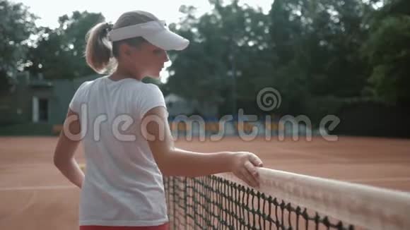 热爱网球运动的青少年网球运动员球拍触网在比赛结束后沿着球场行走视频的预览图