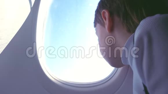 飞机着陆时男孩嚼着口香糖看着窗外的云彩视频的预览图
