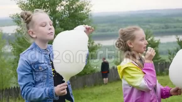 十几岁的女孩在自然公园散步时吃着甜棉花的肖像视频的预览图