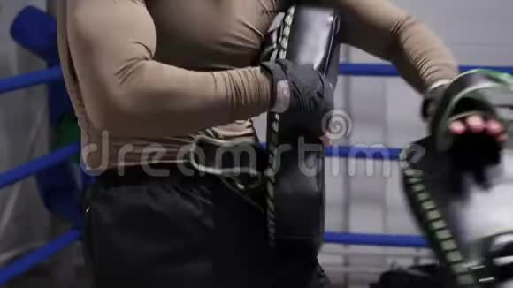 拳击手放置拳击垫与搭档进行个人训练职业拳击手在拳击场上使用脚垫MMA视频的预览图