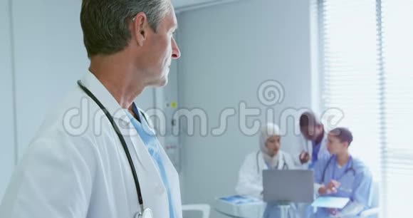高加索男医生在医院看他的同事视频的预览图