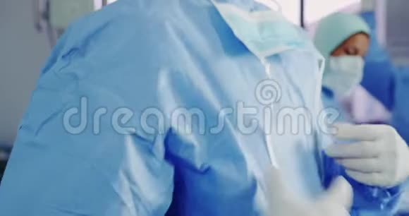 医院手术室戴口罩的白种人男医生的特写视频的预览图