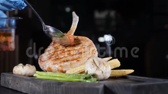 大块多汁的烤牛排美味的猪肉一块肉放在木板上蔬菜都是用火焰煮熟的凹痕视频的预览图