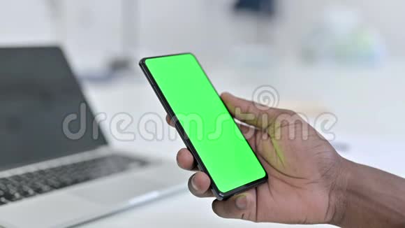 使用绿色智能手机屏幕的非洲男子手视频的预览图