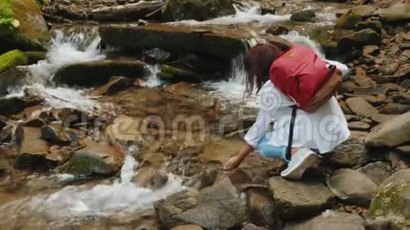 女人正触着河的水流视频的预览图