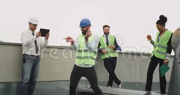 一个年轻的工程师戴着头盔跳起舞来兴奋不已视频的预览图