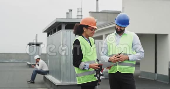 微笑魅力聪明的女士非洲工程师和漂亮的建筑师讨论了建筑工地的问题视频的预览图