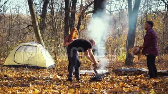秋天森林里篝火的游客视频的预览图
