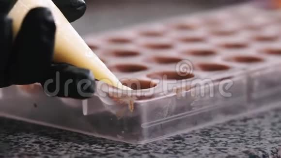 从管道袋中装入巧克力模具的甜点视频的预览图