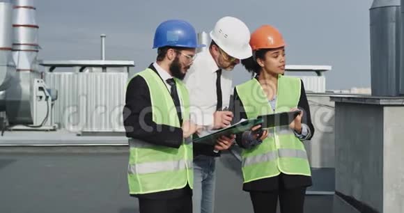 建筑行业的工程师和建筑师小组从平板电脑和板材上分析建筑计划视频的预览图