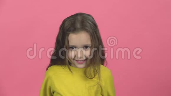 可爱的婴儿在工作室的粉红色背景上微笑着尖叫慢动作视频的预览图