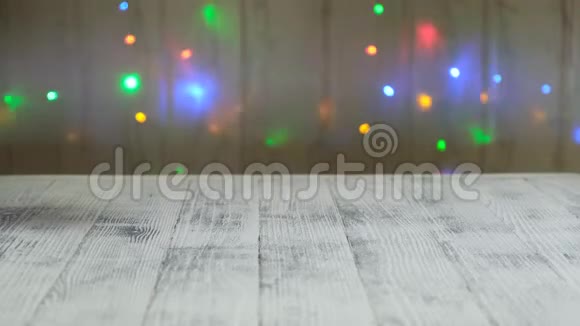 手推迷你购物车与圣诞树和礼物背景的LED灯花环视频的预览图