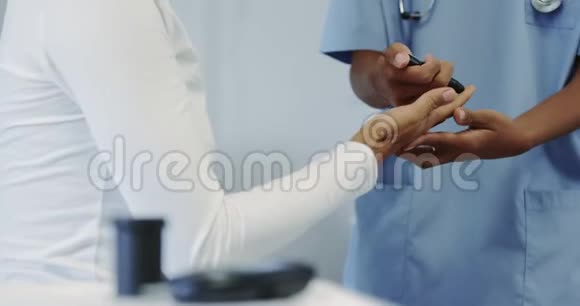 非裔美国女医生在医院病房检查女性患者血糖水平视频的预览图