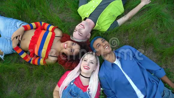 欢乐的多民族朋友一起躺在公园草地上青春自由的连接视频的预览图