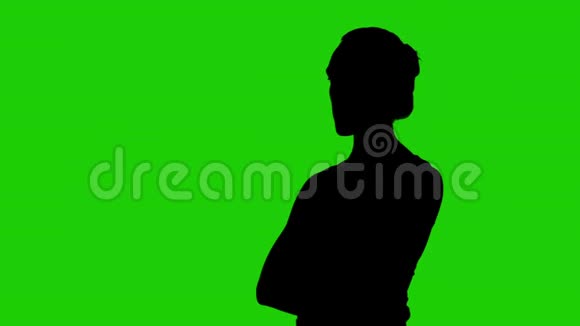 女孩在绿色的背景上交叉着手臂半转侧影视频的预览图