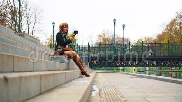 时尚vlogger使用智能手机和stealam在公园录制视频视频的预览图