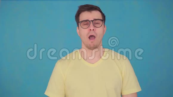 中年男性戴着眼镜和t恤睡意朦胧早起的问题视频的预览图