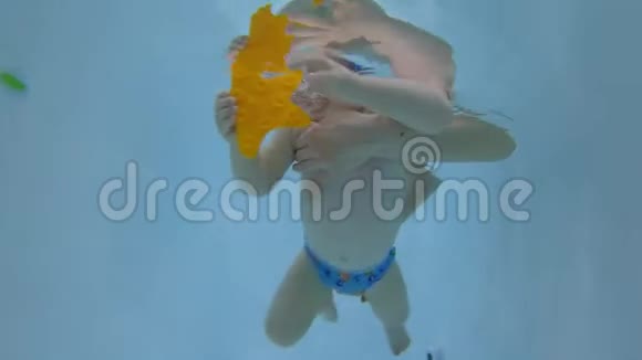 快乐的宝宝在游泳池的水下潜水宝贝学习游泳未编辑的水下录像视频的预览图