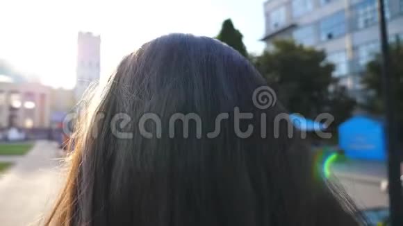 无法辨认的女人会在清晨的街道上工作和整理头发一个漂亮的女孩视频的预览图