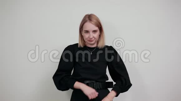 严严实实的年轻女子挽着围巾双手交叉在白墙上视频的预览图