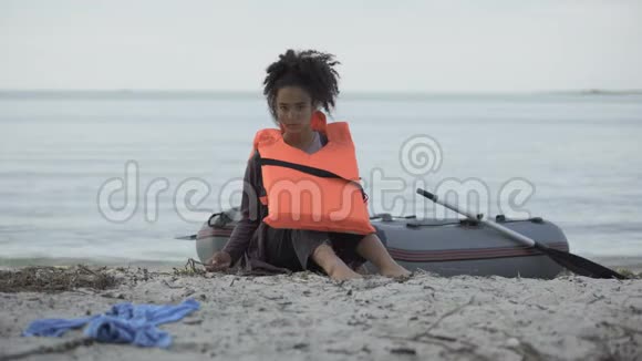 少女穿着救生衣坐在船边难民在船上幸存下来视频的预览图