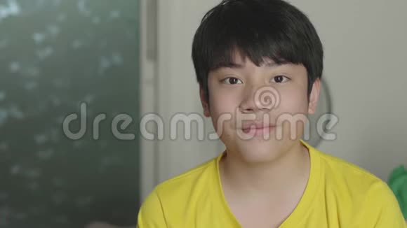 亚洲男孩看电影和吃爆米花在家享受视频的预览图