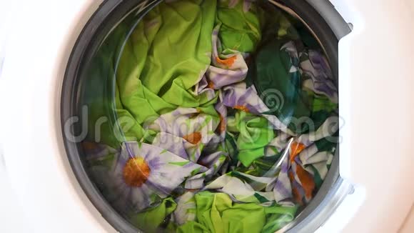用干净的彩色衣服在洗衣机上特写烘干洗衣服视频的预览图
