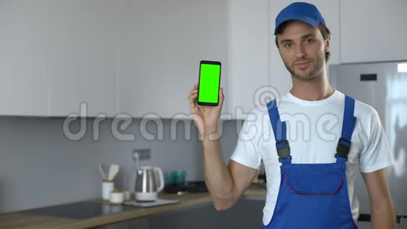 穿制服的男子带绿色屏幕显示电话预订房屋维修服务视频的预览图