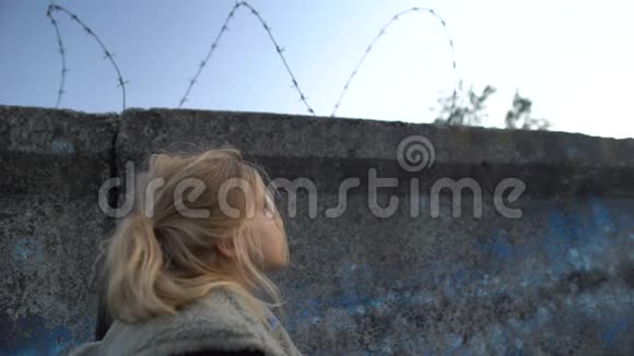 小难民女孩看着铁丝网梦想着新的家园移民视频的预览图
