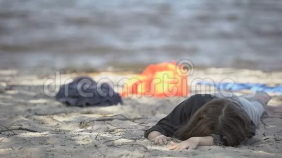 不幸的女人躺在岸上感觉不舒服遇难的难民幸存者视频的预览图