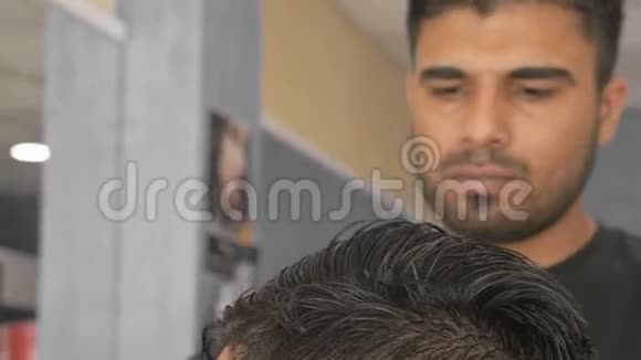 理发师在理发店用剪刀剪头发视频的预览图