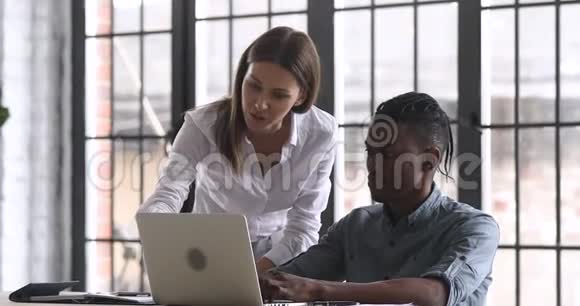 帮助非洲实习生解释工作场所计算机工作的女性导师视频的预览图