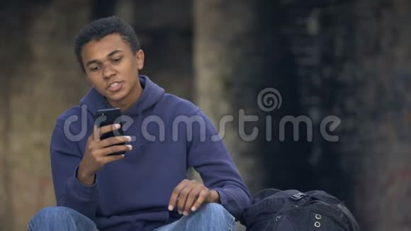 非洲青少年看着愤怒的阅读智能手机信息家庭问题危机视频的预览图