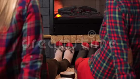 两个女孩坐在壁炉旁穿着袜子像一只鹿舒适的壁炉旁有几英尺的袜子视频的预览图
