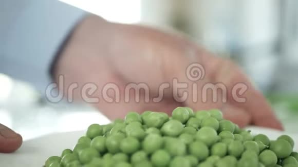 男士双手奉上一盘鲜嫩的绿色豌豆视频的预览图