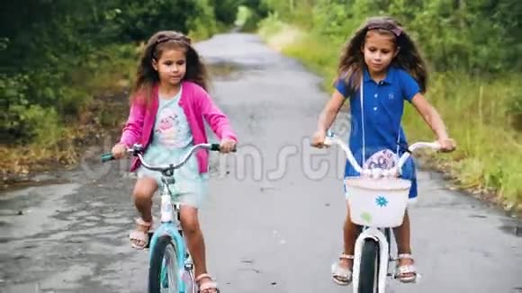 两个女孩骑着孩子们自行车在树上视频的预览图