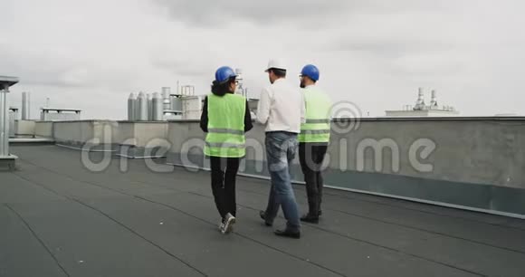 从建筑工地后屋顶拍摄视频一名建筑师和两名工程师多民族分析视频的预览图