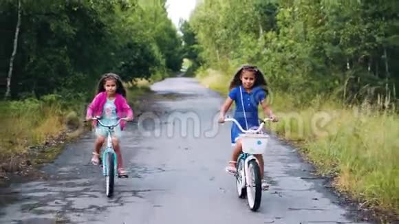 两个女孩骑着孩子们自行车在树上视频的预览图