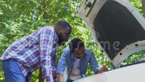 黑人爸爸赞扬十几岁的儿子学习修理汽车家庭团聚视频的预览图