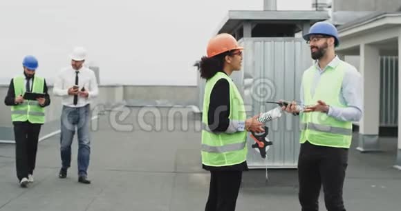 一群工人在建筑工地上工程师建筑师商人在建筑的屋顶上开会视频的预览图