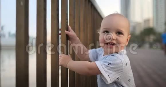 笑的男孩一岁的时候抱着栏杆跳舞学着走路站在一个台阶上视频的预览图