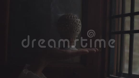 面无表情的手拿着香火在暗室室内抄文字空间冒着黑烟的白烟视频的预览图
