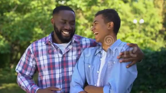 年轻的黑人拥抱着弟弟一起笑着玩一家人视频的预览图